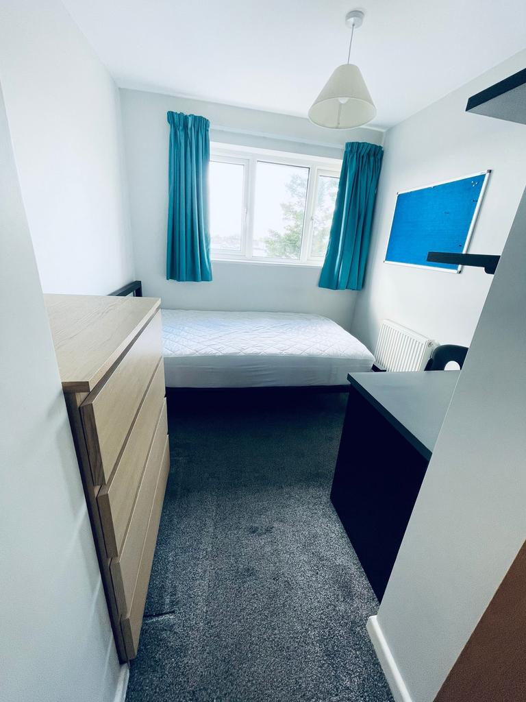 Bright single bedroom with a large window, cris...