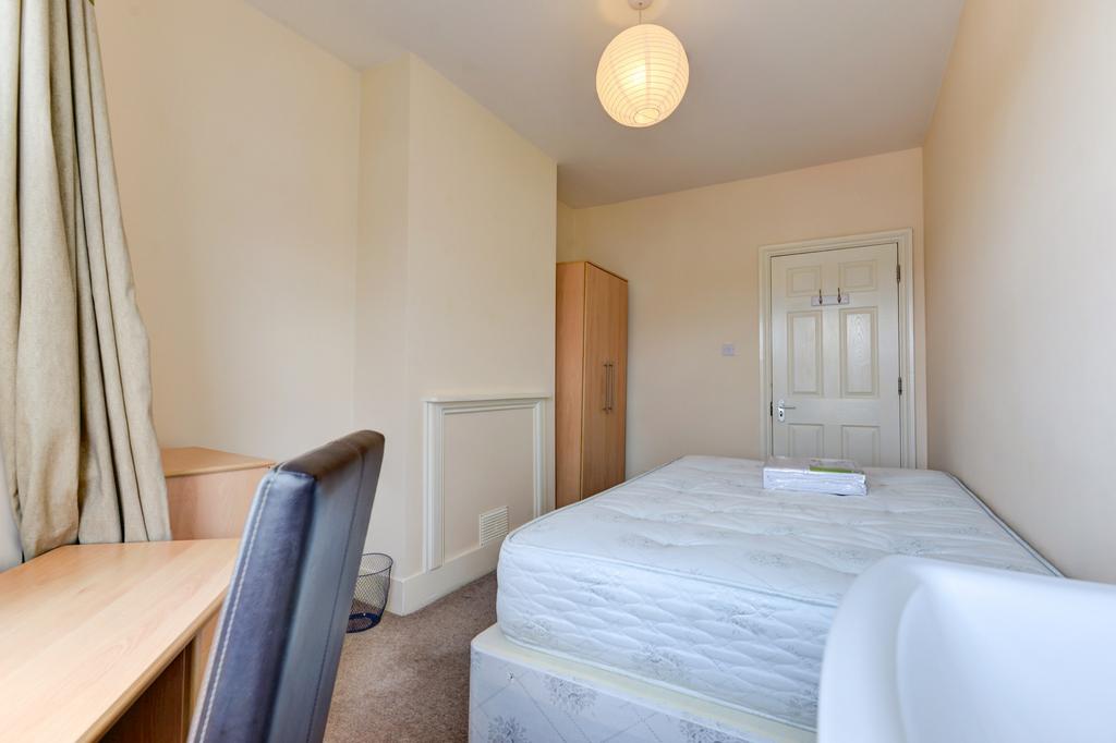 Bright, simply furnished bedroom with a comfort...