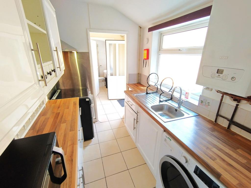 Bright, modern galley kitchen with wooden count...