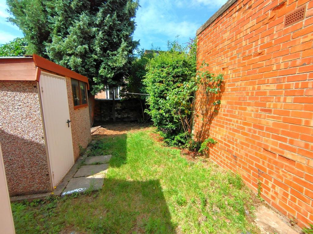 Sunny enclosed rear garden with lawn, mature sh...