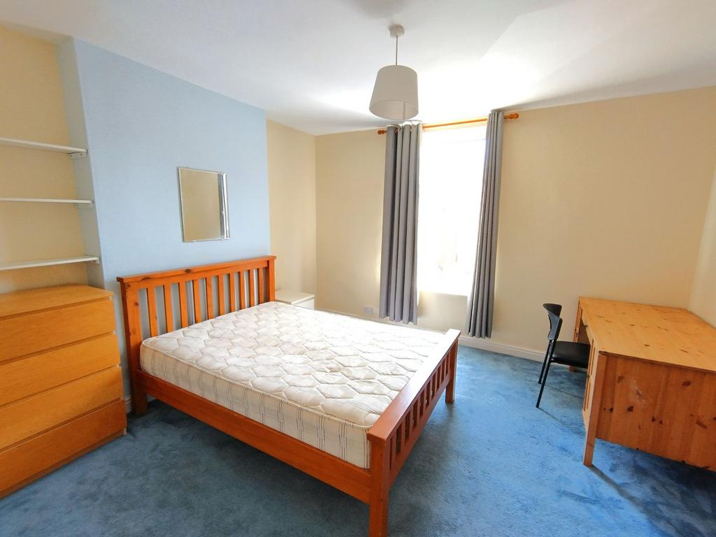 Bright, well-presented bedroom with a wooden do...