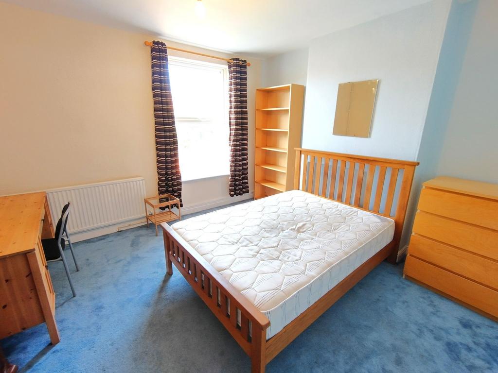 Bright double bedroom with a wooden double bed,...