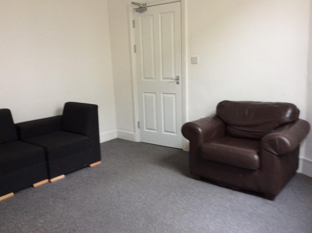 A comfortable living room featuring two black s...