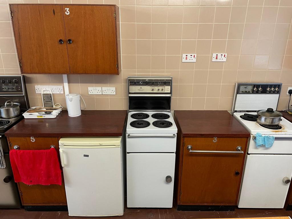 Well-equipped communal kitchen area with multip...