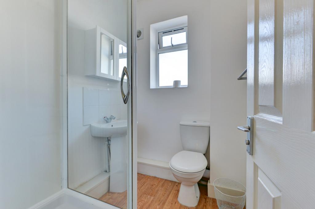 A clean and bright bathroom with a toilet, smal...