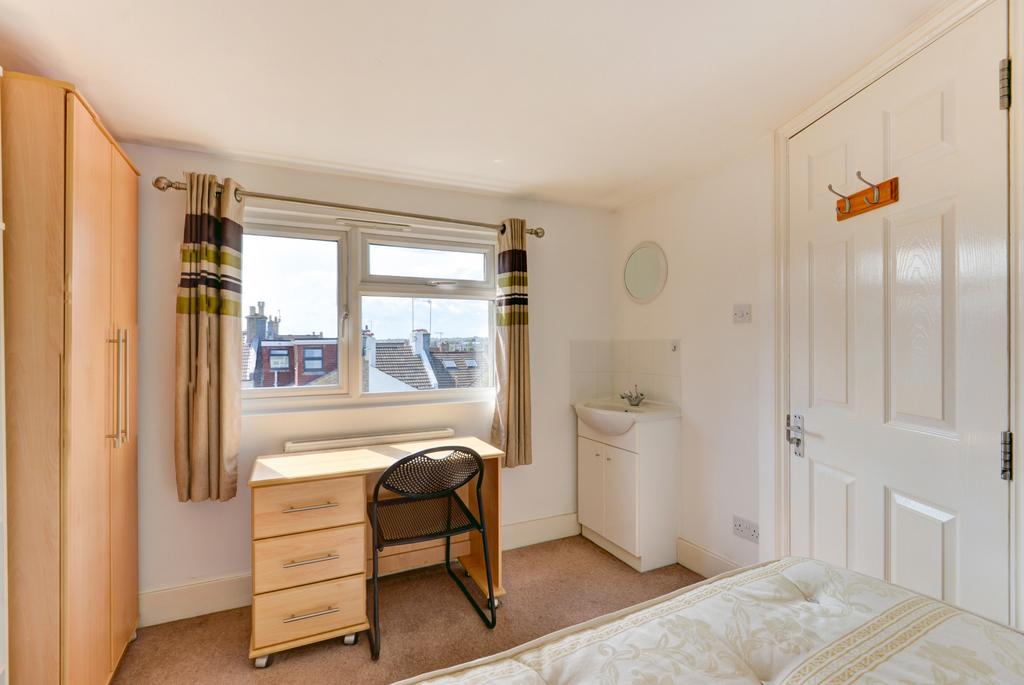 Bright, tidy bedroom with a large window, desk ...