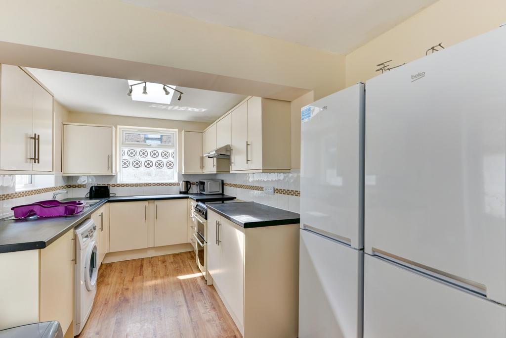 Bright modern kitchen with light cabinetry, bla...