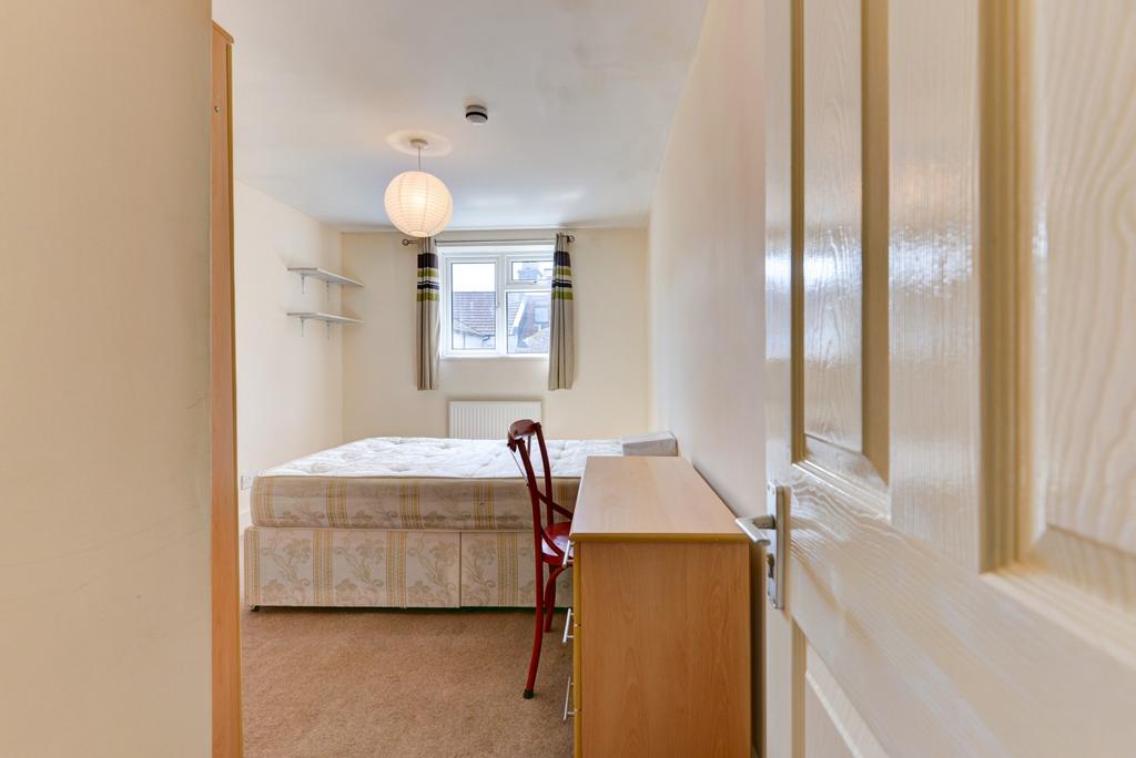 Bright, simply furnished bedroom with a single ...