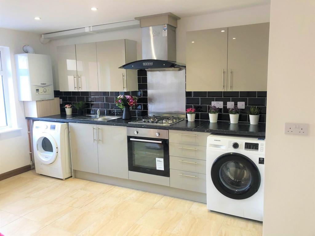 Bright, modern kitchen with sleek cabinetry, in...
