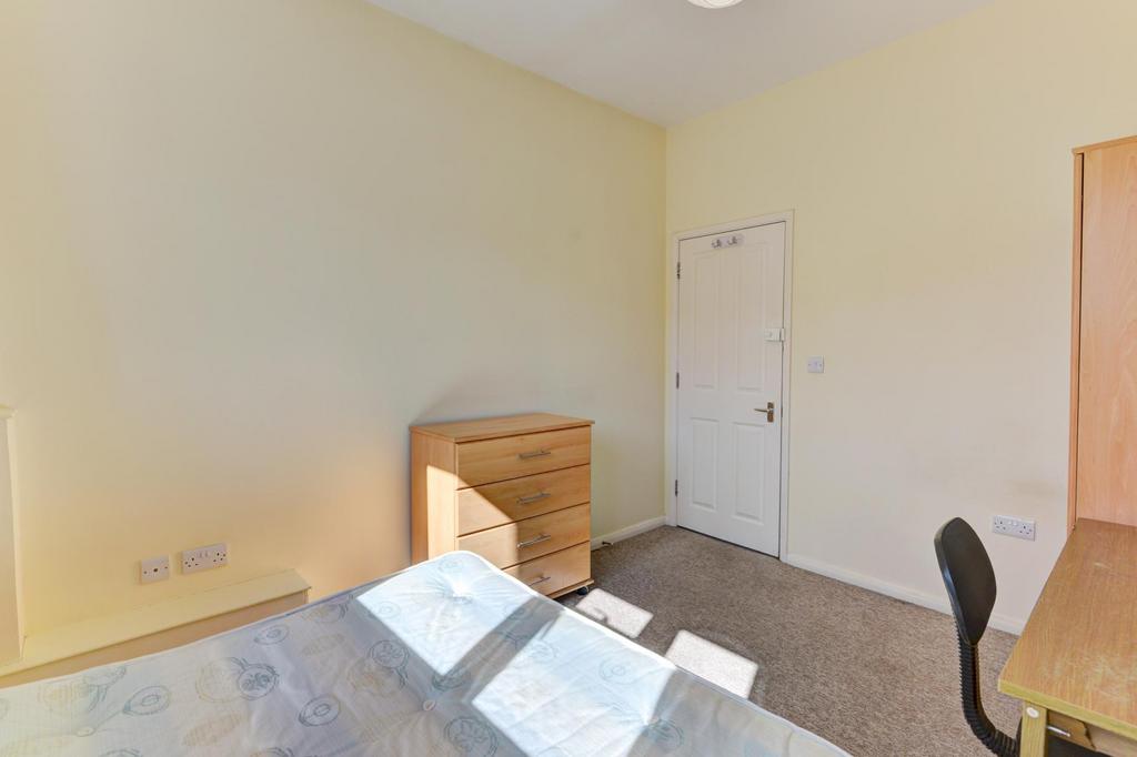 Bright, simply furnished bedroom with a large w...