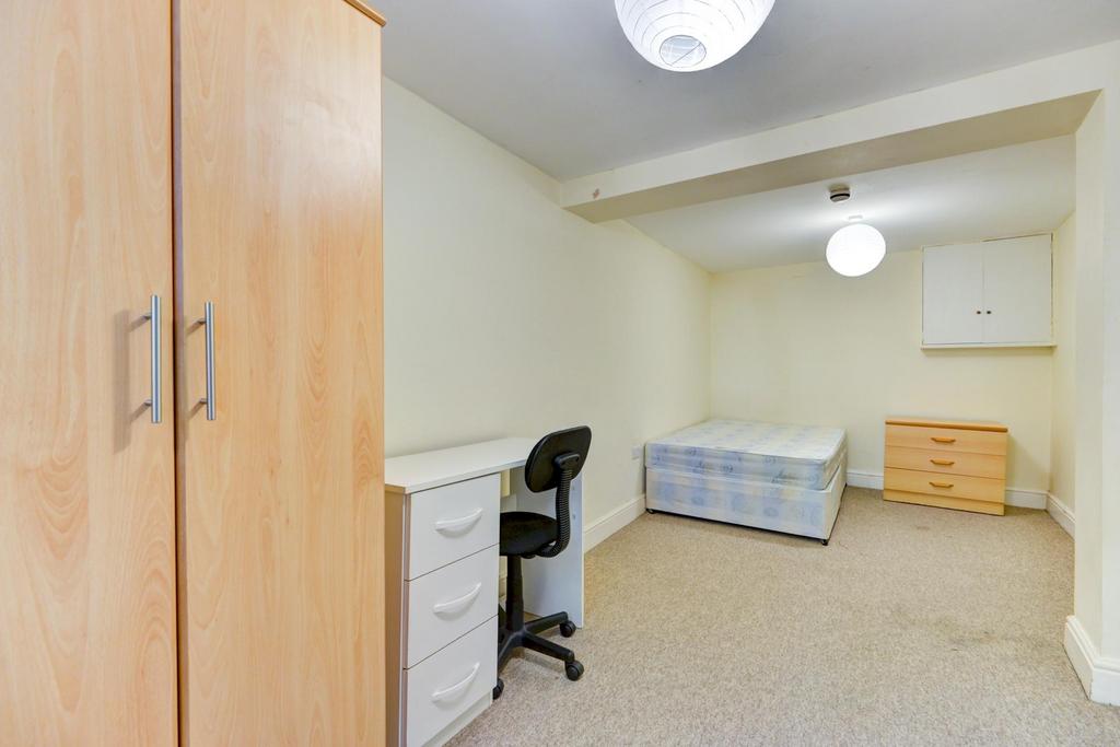 A cozy bedroom with a single bed and a small st...