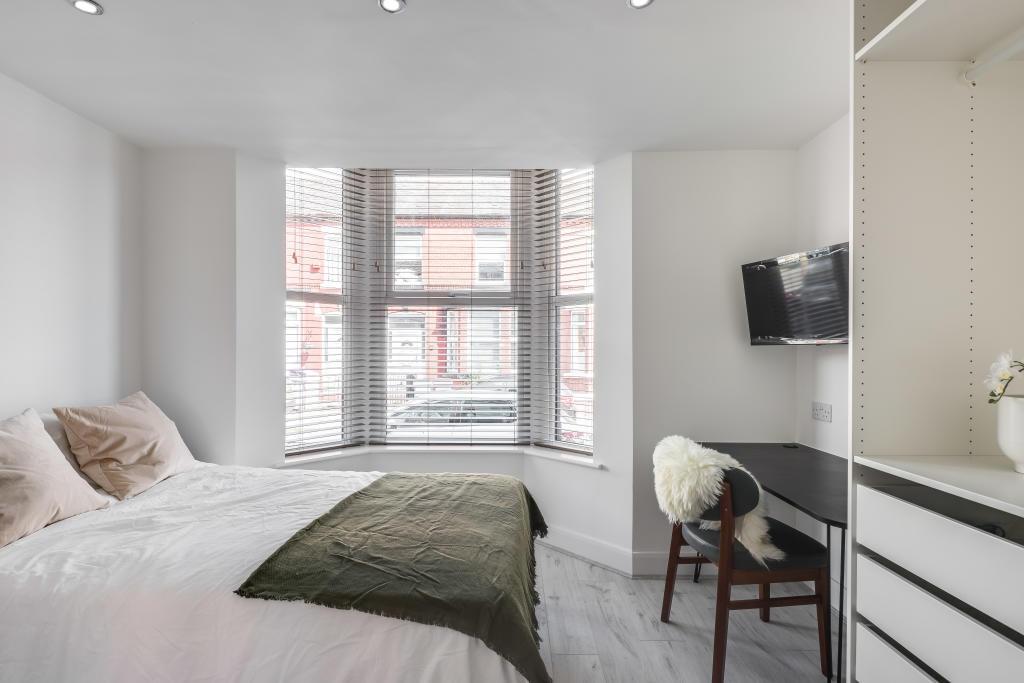 Bright and spacious master bedroom with large w...