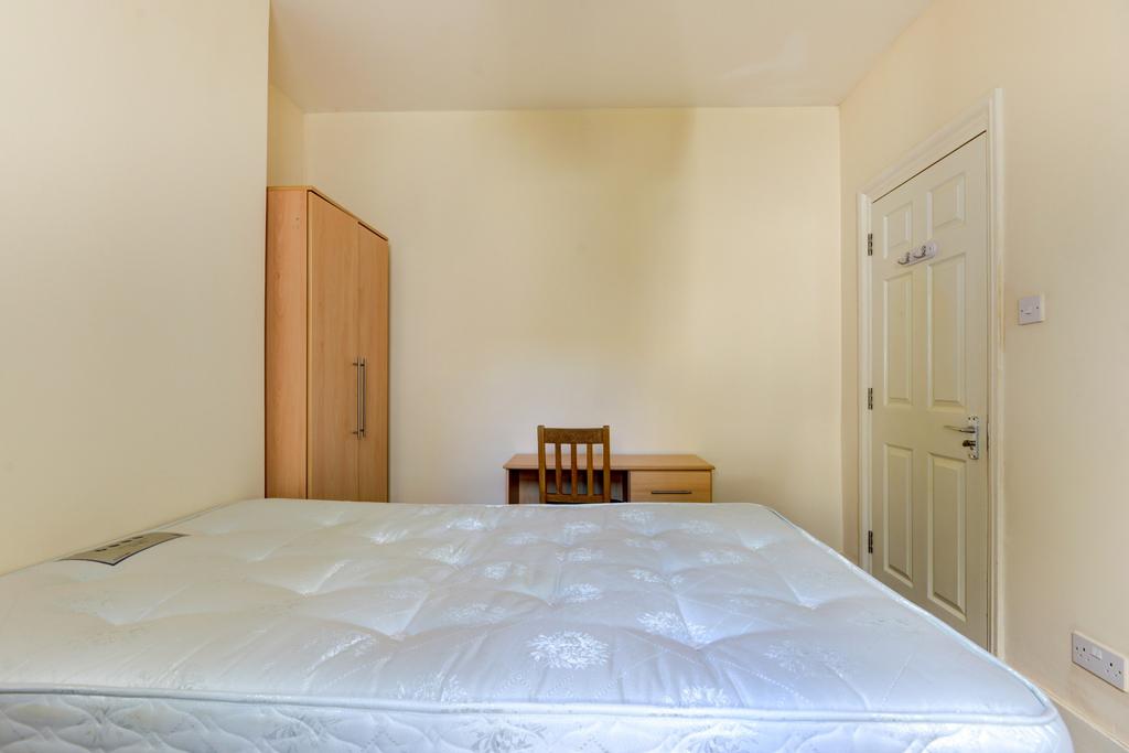 Bright, simply furnished bedroom featuring a do...