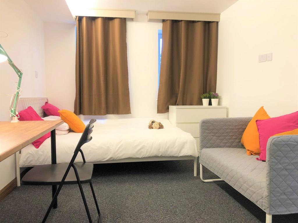 A bright and tidy single bedroom featuring a co...