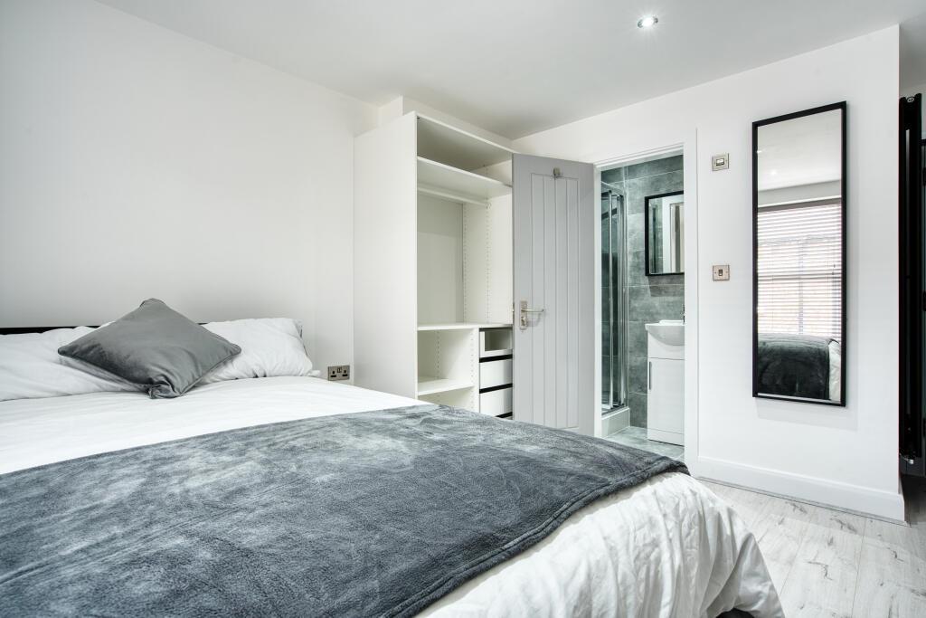 Bright and modern master bedroom featuring a co...