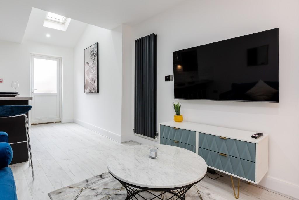 A bright and modern living room featuring a lar...
