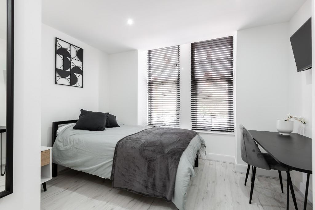 Bright and modern master bedroom featuring a co...