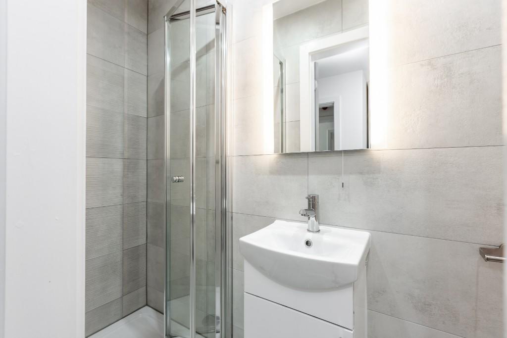 A modern, clean bathroom featuring a large show...