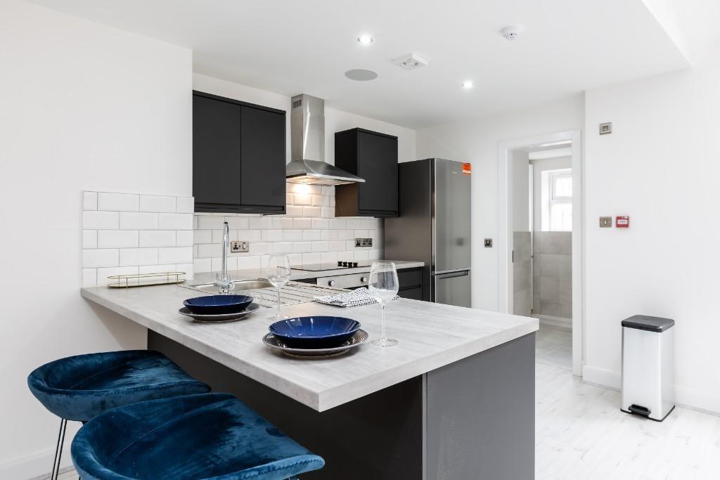 A modern, bright kitchen featuring a spacious w...