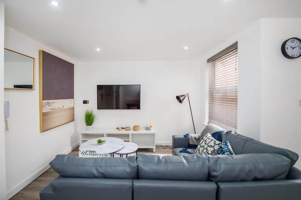 A modern, well-lit living room featuring a comf...
