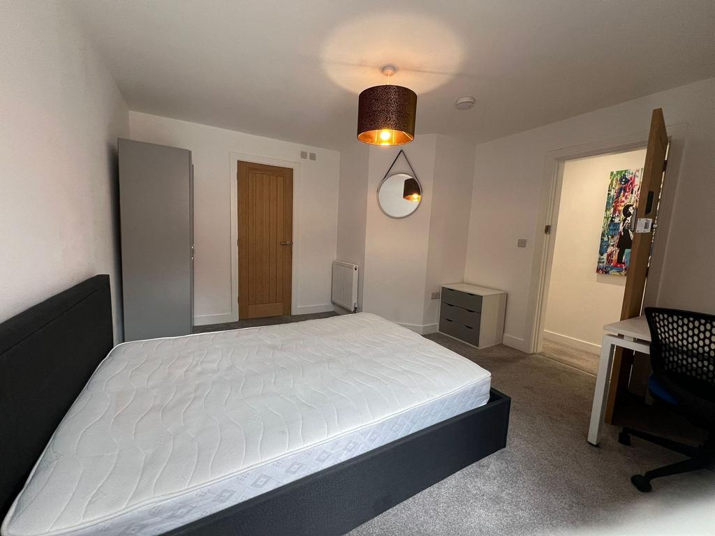 Bright, neutrally decorated double bedroom with...