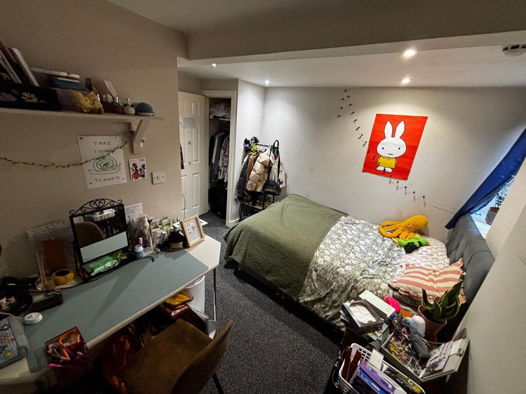 Cosy furnished bedroom with a double bed agains...