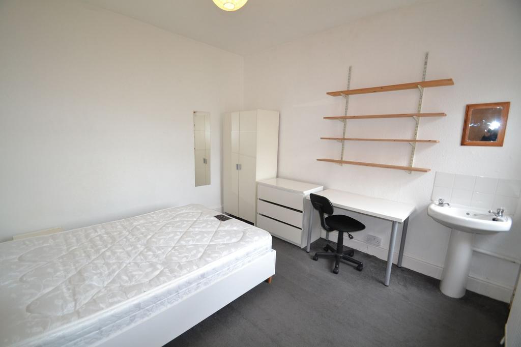 A simple, tidy single bedroom featuring a bed, ...