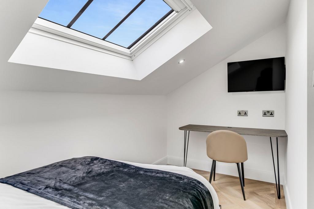Bright and modern bedroom with a ceiling skylig...