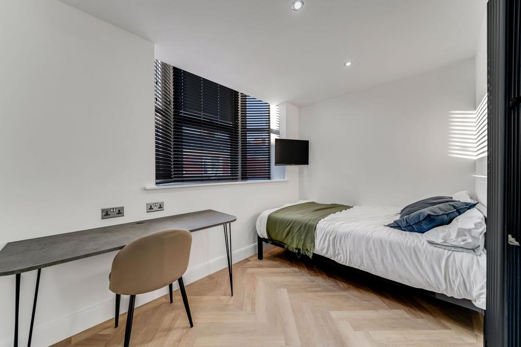 A modern, well-lit single bedroom featuring a c...