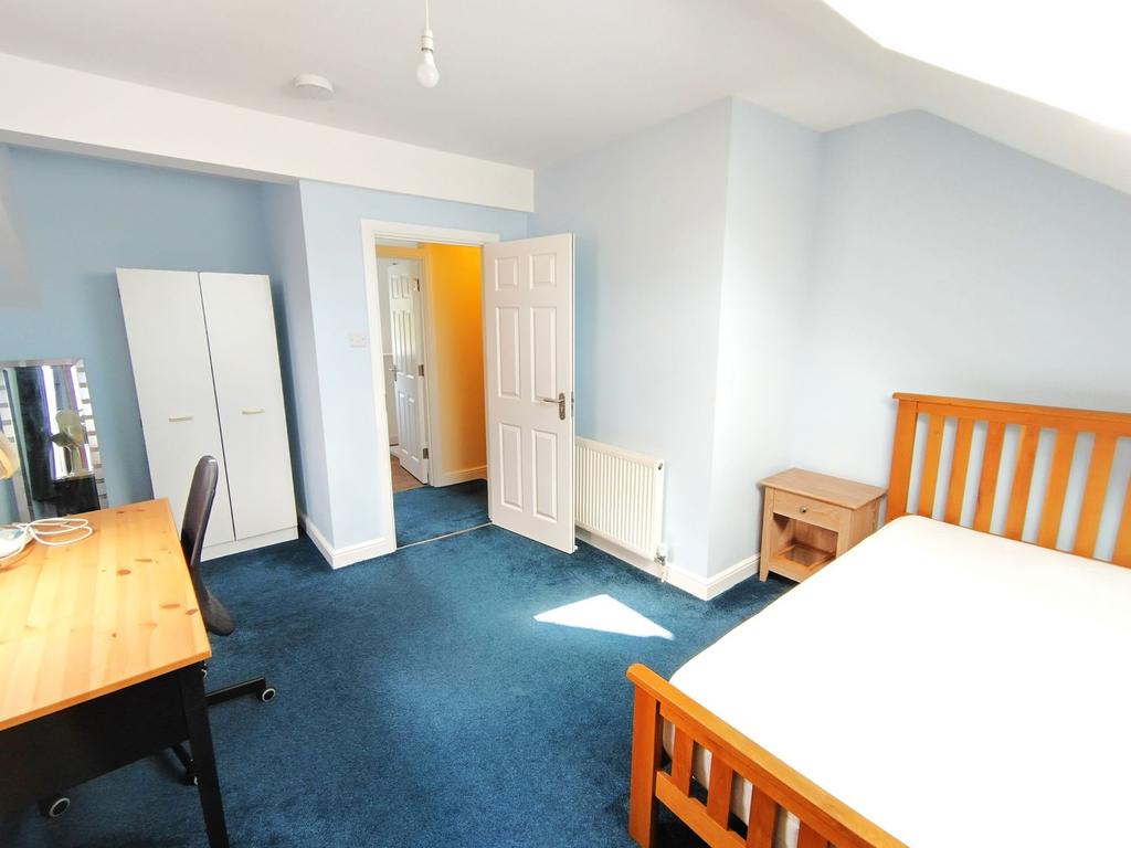 Bright, freshly painted bedroom with a wooden d...