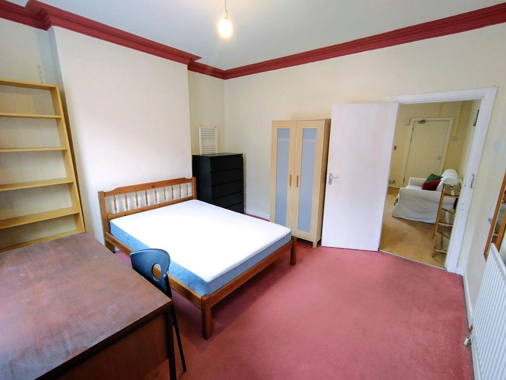 Bright, well-kept double bedroom with a wooden ...