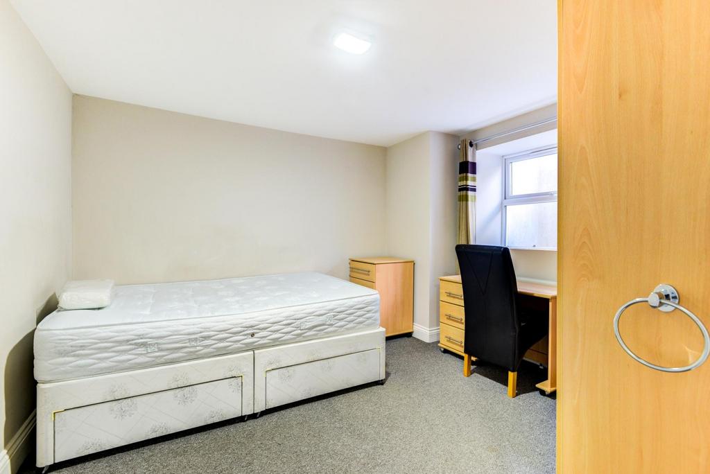 Bright, simply furnished bedroom with a comfort...