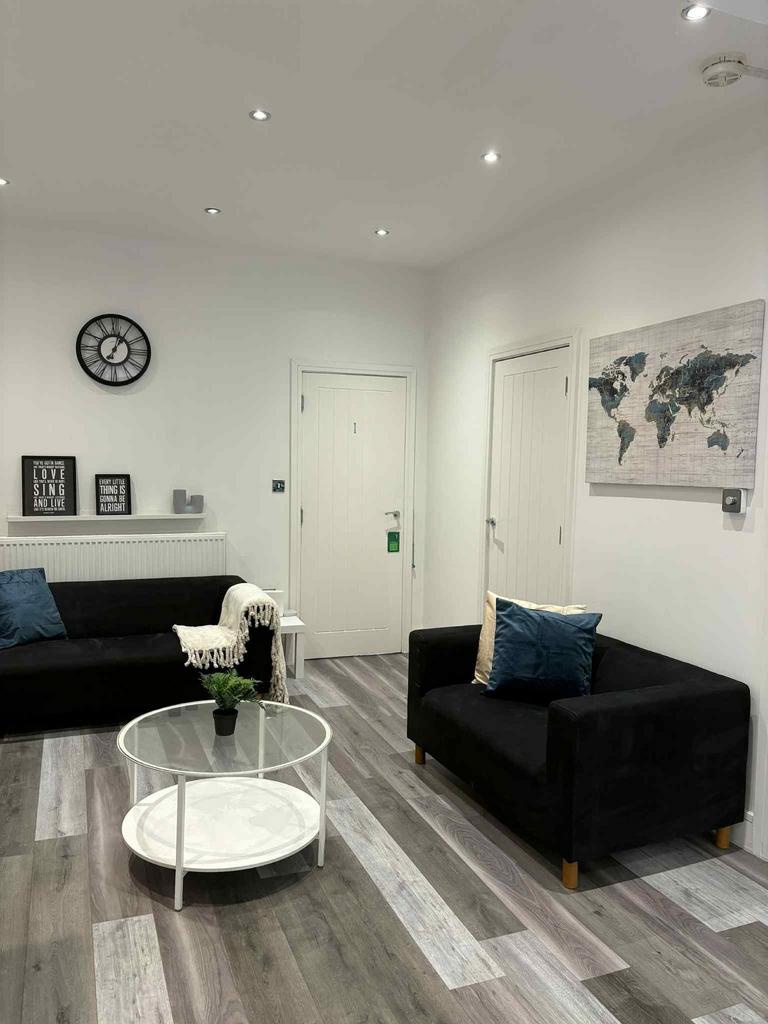 A modern, well-lit living room featuring two bl...