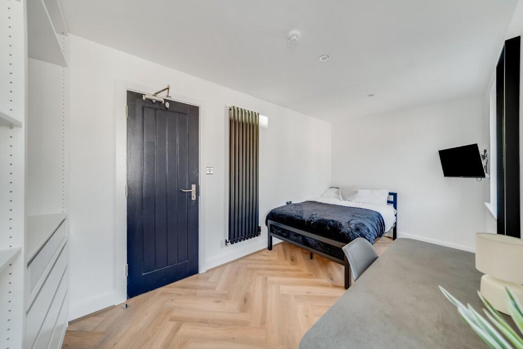 A modern, well-lit bedroom with a comfortable d...
