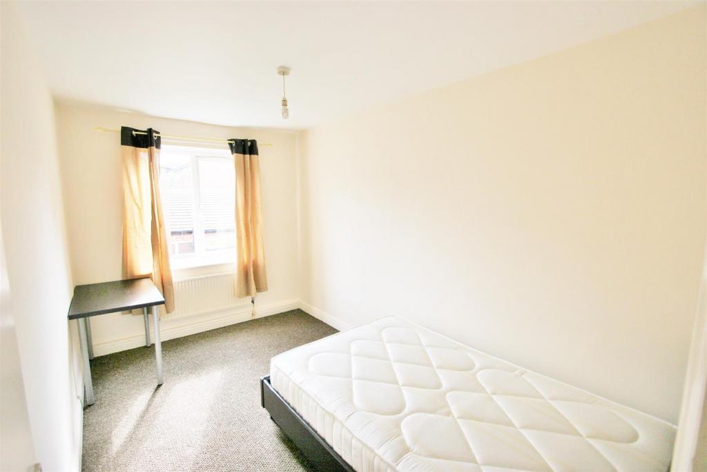 A bright and simple single bedroom with a windo...