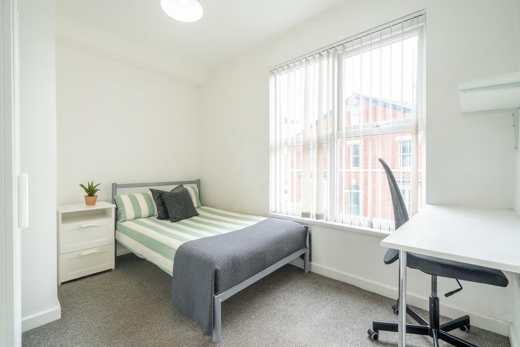 Bright and inviting bedroom featuring a fresh, ...