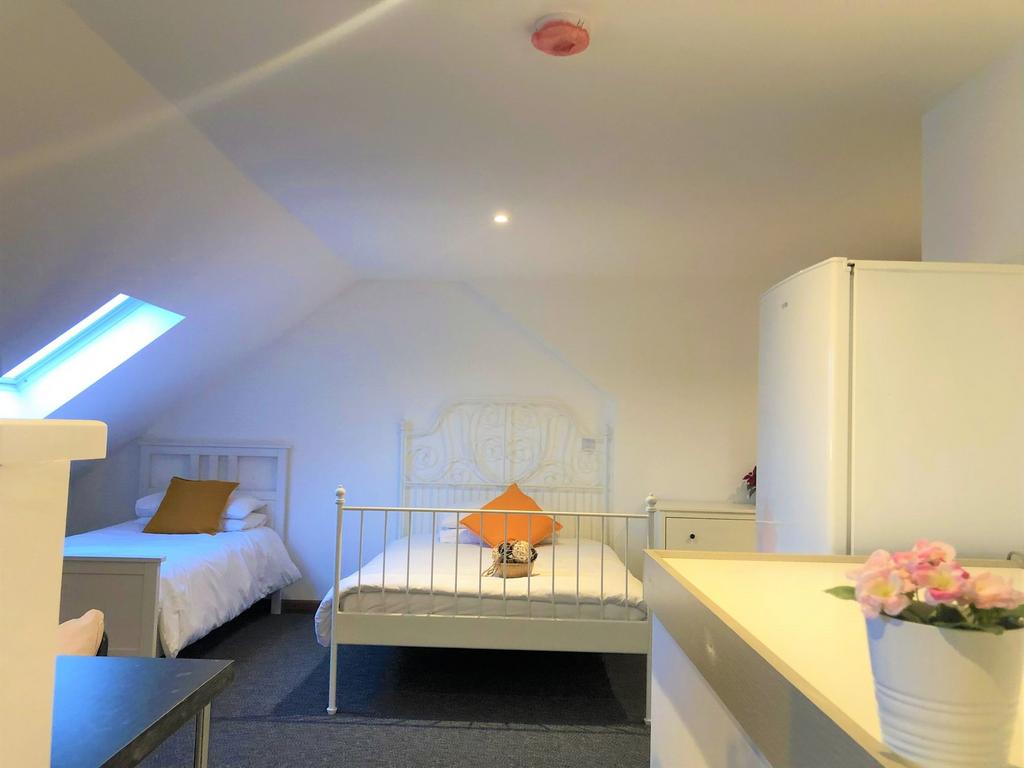 A bright and clean double bedroom featuring two...