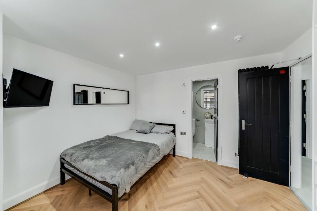 A modern, well-lit bedroom featuring a double b...
