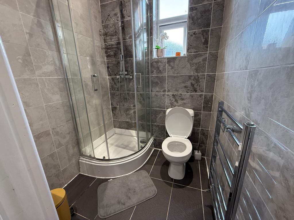 Modern tiled bathroom with a curved glass showe...