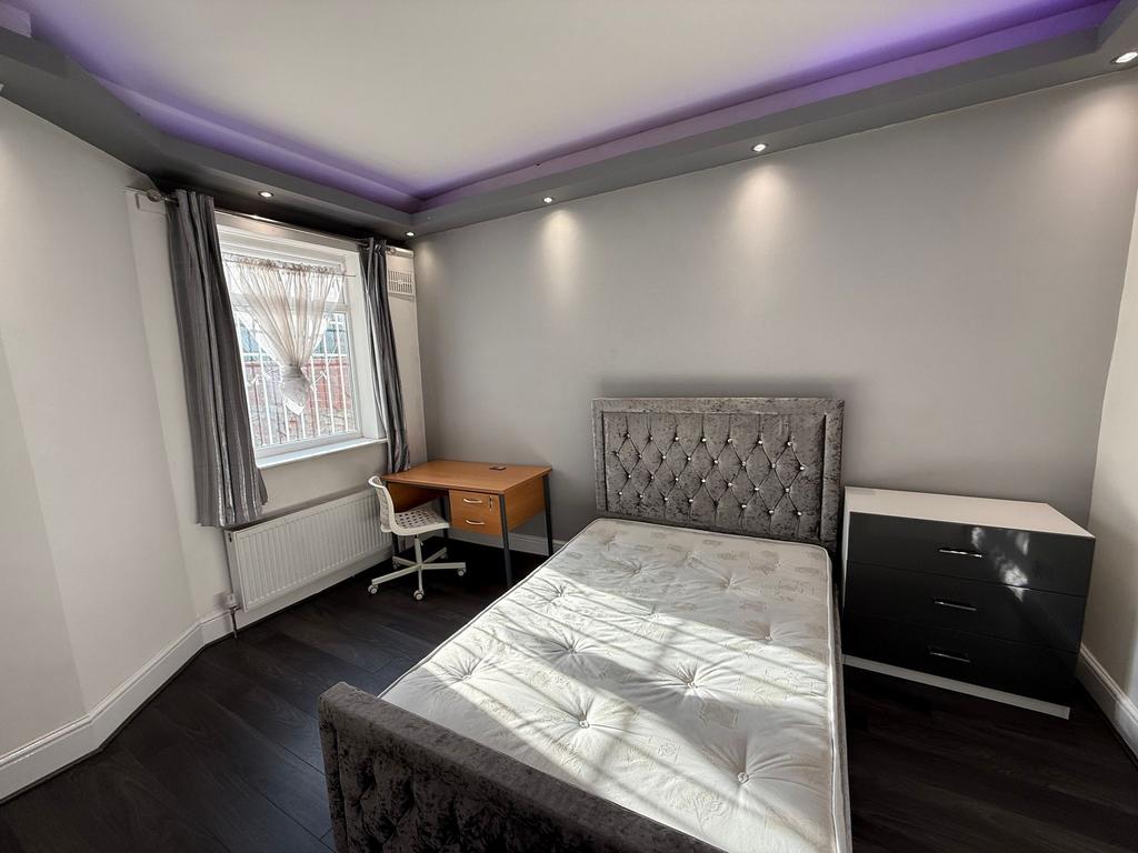 Bright, modern double bedroom with a plush upho...