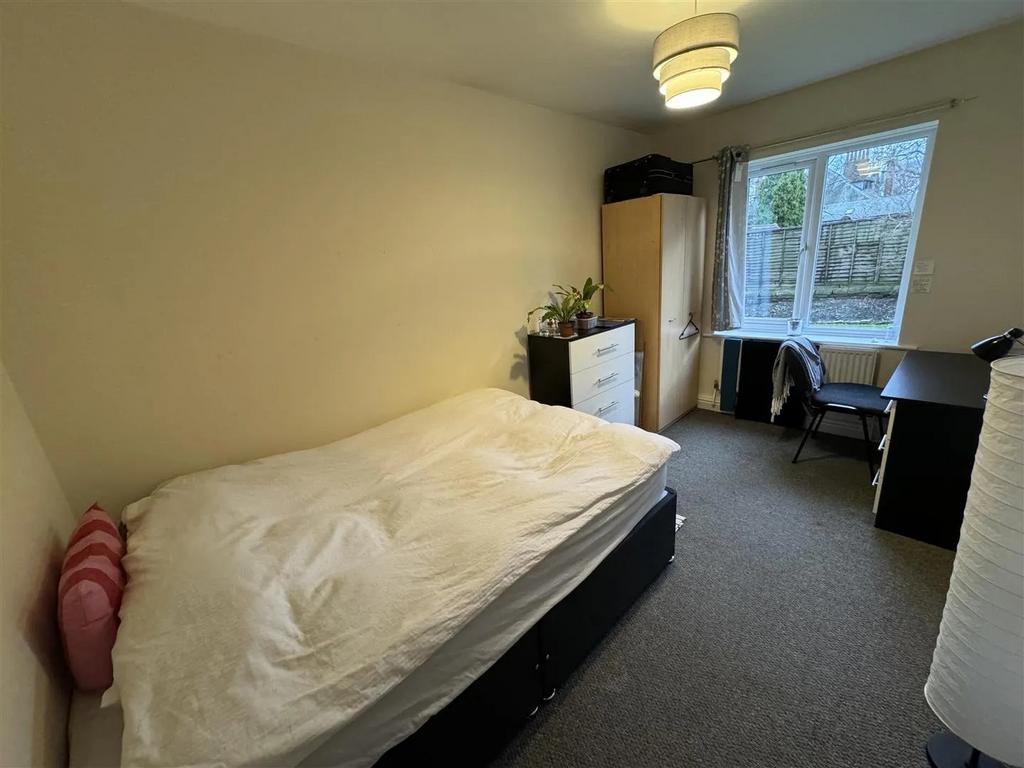 A cozy single bedroom featuring a comfortable b...
