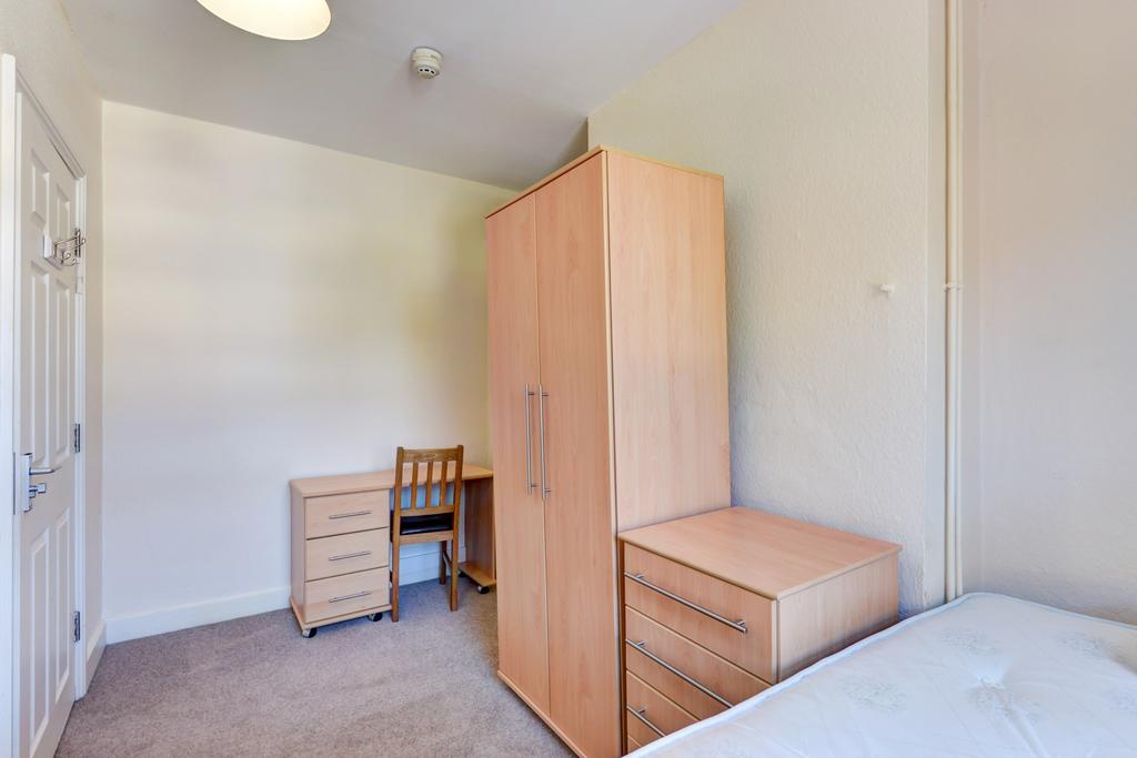 A neat and orderly bedroom featuring a single b...