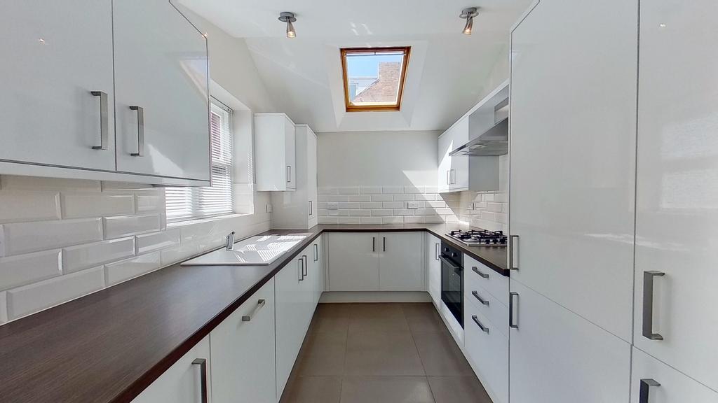 Contemporary galley kitchen with glossy white c...