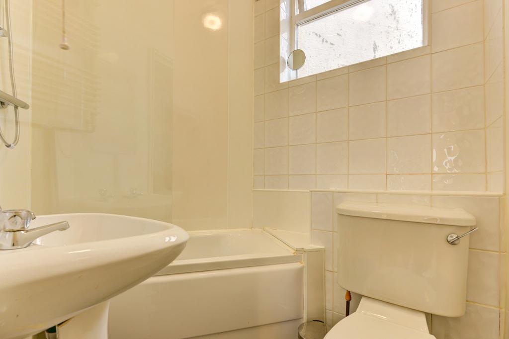 Bright, clean bathroom with a white suite, show...