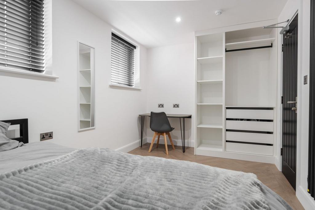 A bright and modern bedroom featuring a neatly ...