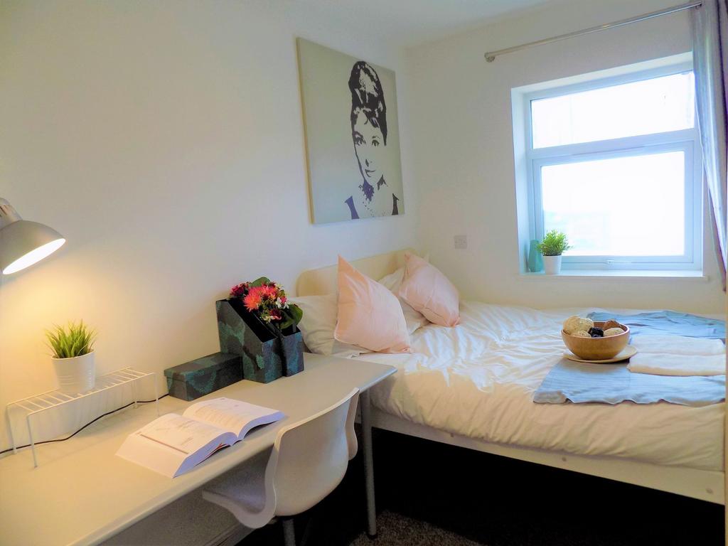 Bright and tidy single bedroom featuring a cozy...
