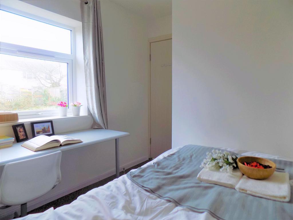 A cozy, well-lit bedroom featuring a comfortabl...