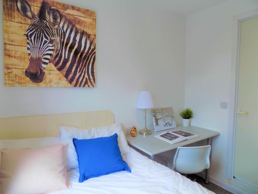 A cozy single bedroom featuring a clean, white ...