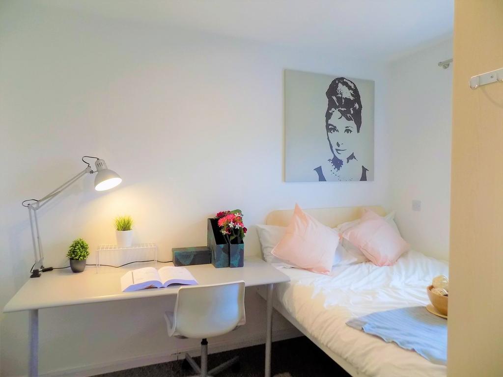 A cozy and neat single bedroom featuring a well...