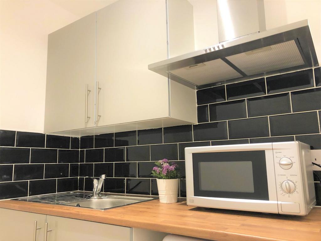 Modern kitchen featuring sleek black subway til...